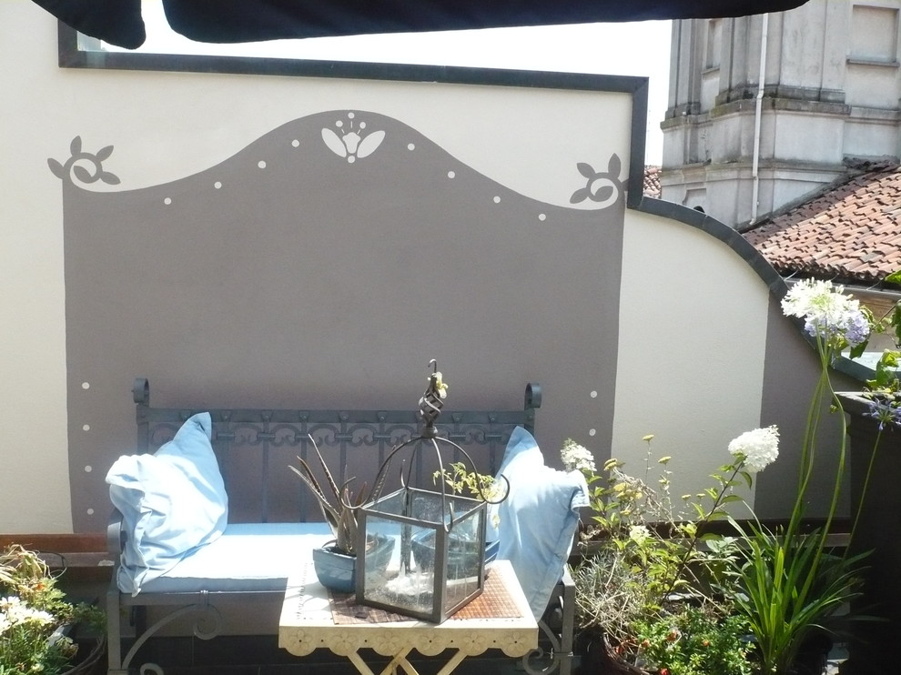 Immagine di una piccola terrazza stile shabby sul tetto con un giardino in vaso e un parasole