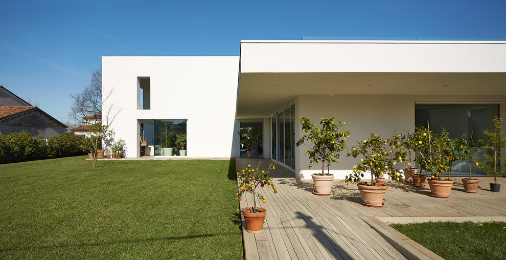 Idee per una grande terrazza minimalista con un giardino in vaso e un tetto a sbalzo