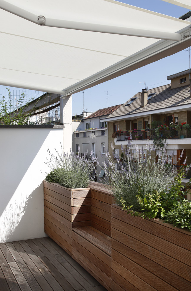 Inspiration for a mid-sized contemporary deck remodel in Milan with an awning