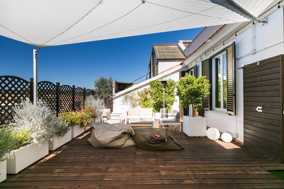 Modelo de terraza actual con jardín de macetas y toldo