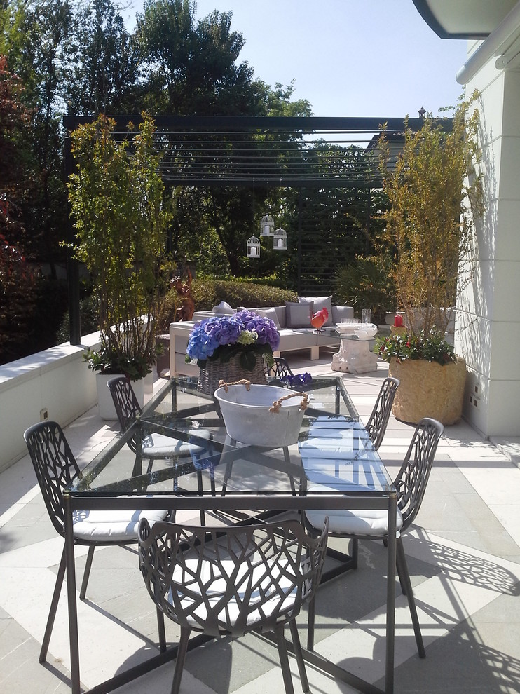 Modelo de terraza contemporánea de tamaño medio en patio lateral con jardín de macetas