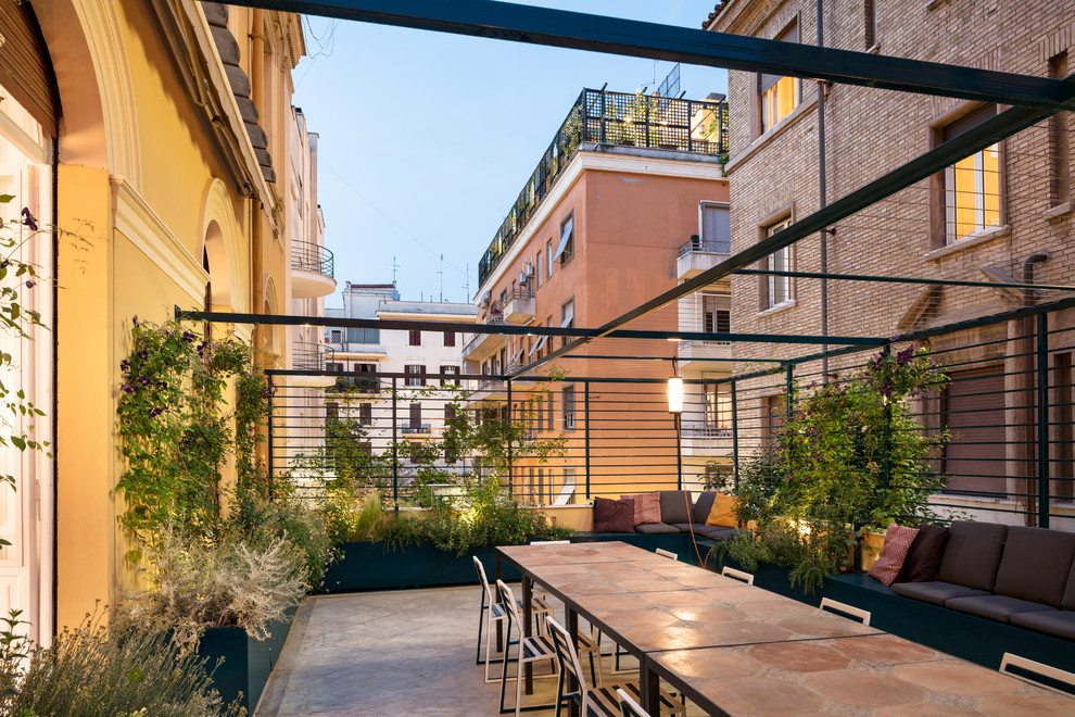 Diseño de terraza actual de tamaño medio con jardín de macetas y pérgola
