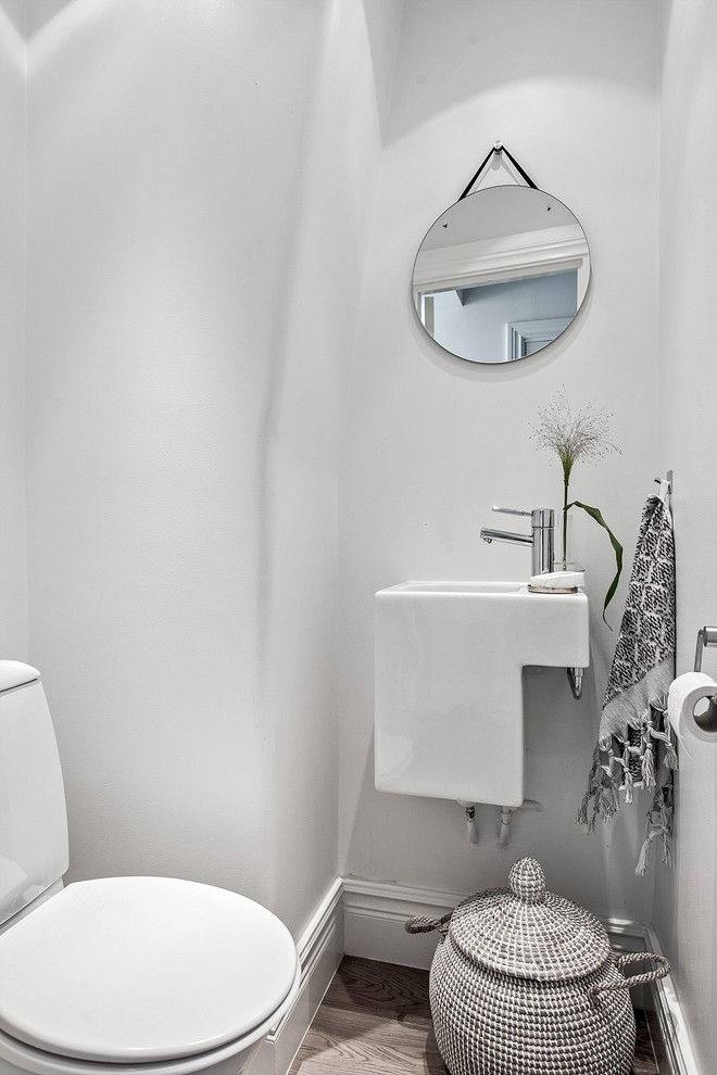Foto på ett litet nordiskt toalett, med vita väggar och ett väggmonterat handfat