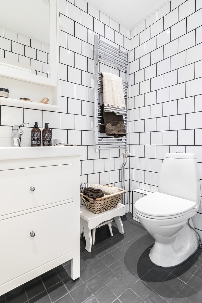 Inspiration for a mid-sized scandinavian white tile and porcelain tile gray floor powder room remodel in Other with flat-panel cabinets, white cabinets, a two-piece toilet, white walls and an integrated sink
