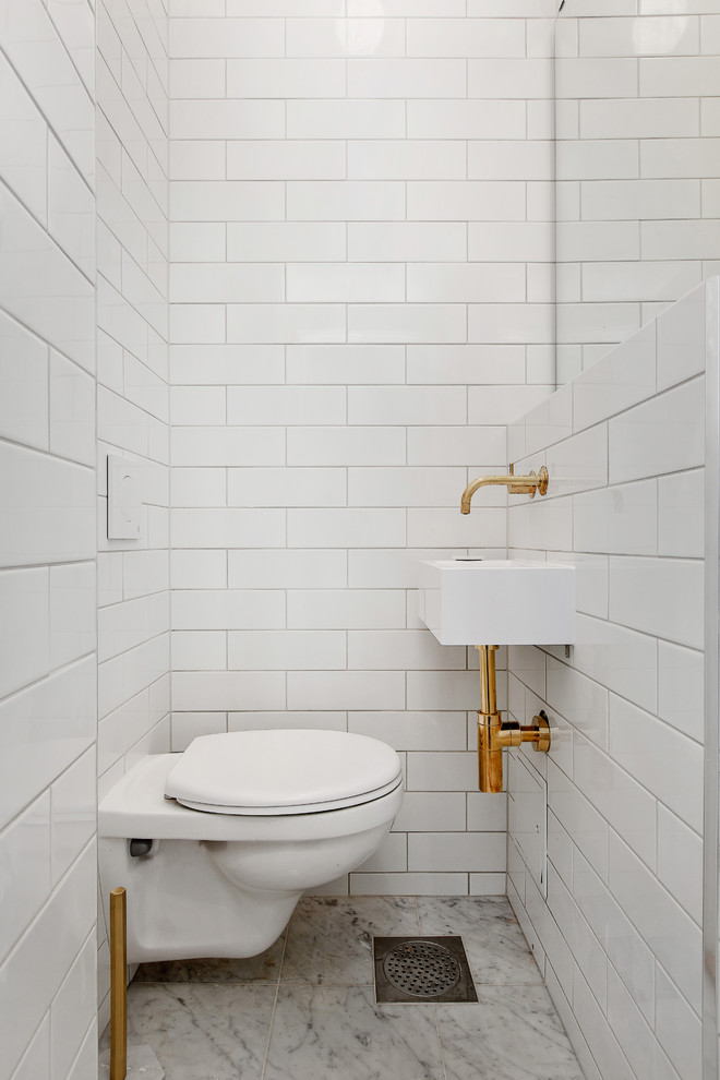 Ispirazione per un bagno di servizio scandinavo di medie dimensioni con WC a due pezzi, piastrelle bianche, piastrelle diamantate, pareti bianche, pavimento in marmo e lavabo sospeso