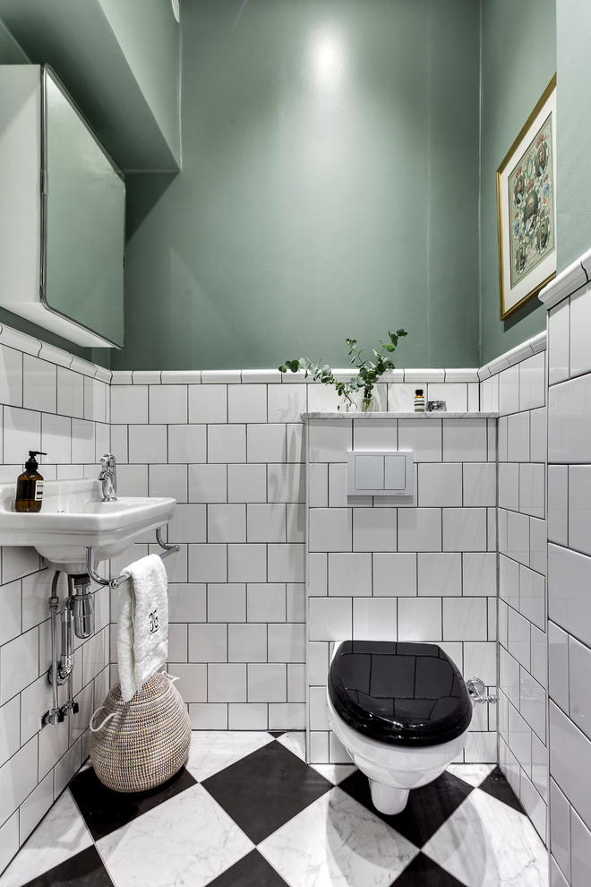 Idéer för små vintage toaletter, med svart och vit kakel, vit kakel, gröna väggar, ett väggmonterat handfat, en vägghängd toalettstol, porslinskakel och flerfärgat golv
