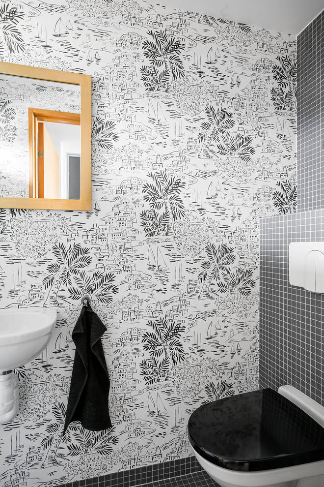 Inspiration för ett funkis toalett, med en vägghängd toalettstol, svart kakel, ett väggmonterat handfat och svart golv