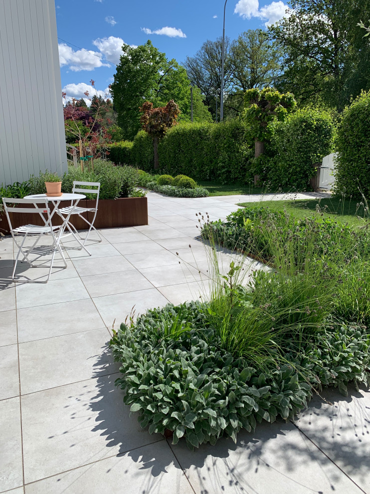 Exempel på en mellanstor minimalistisk formell trädgård framför huset