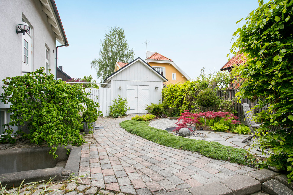 Exempel på en stor klassisk formell trädgård framför huset på våren, med en trädgårdsgång