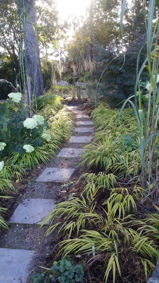 Esempio di un grande giardino tradizionale esposto a mezz'ombra in primavera con un ingresso o sentiero, un pendio, una collina o una riva e pavimentazioni in cemento