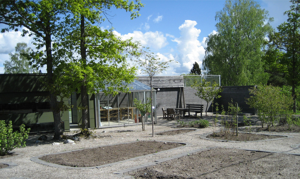 Inredning av en modern mellanstor trädgård i full sol, med grus