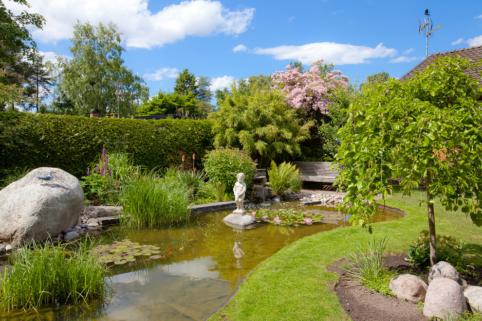 Geometrischer, Mittelgroßer Klassischer Garten im Frühling, hinter dem Haus mit Wasserspiel und Mulch in Malmö