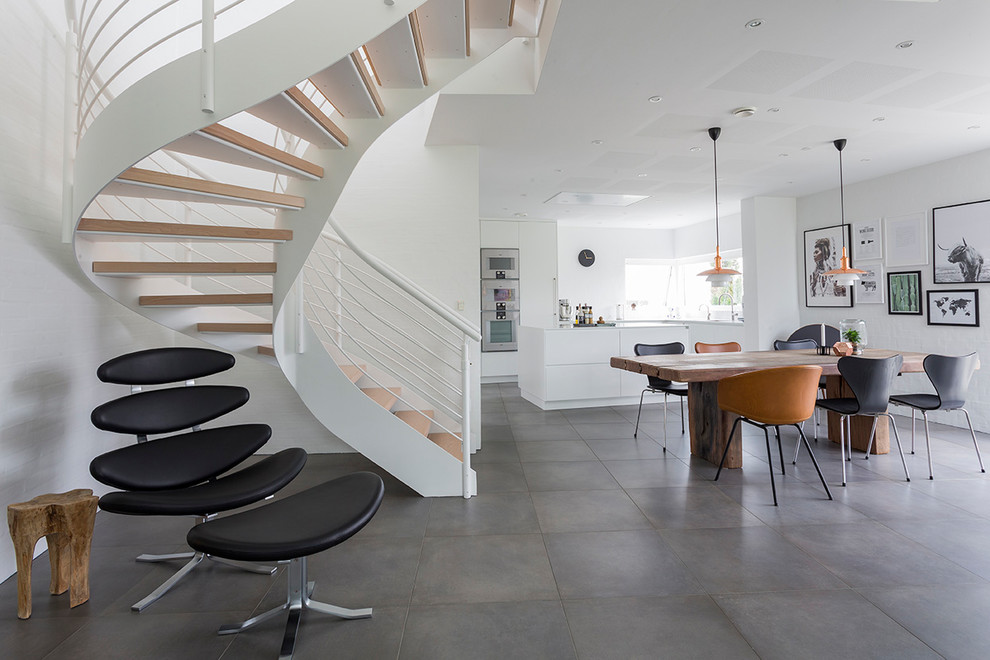 Große, Gewendelte Moderne Holztreppe mit offenen Setzstufen und Stahlgeländer in Sonstige