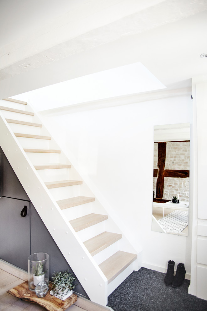 На фото: прямая лестница среднего размера в скандинавском стиле с деревянными ступенями и крашенными деревянными подступенками