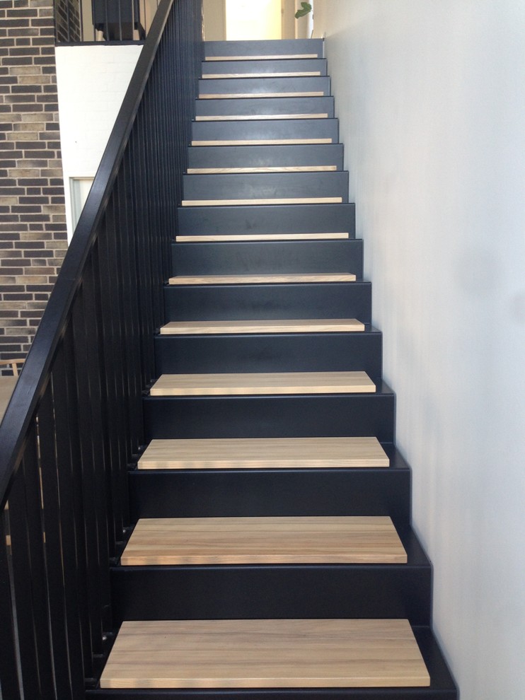 Modelo de escalera escandinava con escalones de metal, contrahuellas de madera y barandilla de metal