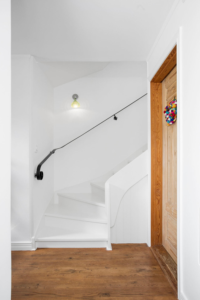 Ejemplo de escalera curva de estilo de casa de campo con escalones de madera pintada y contrahuellas de madera pintada