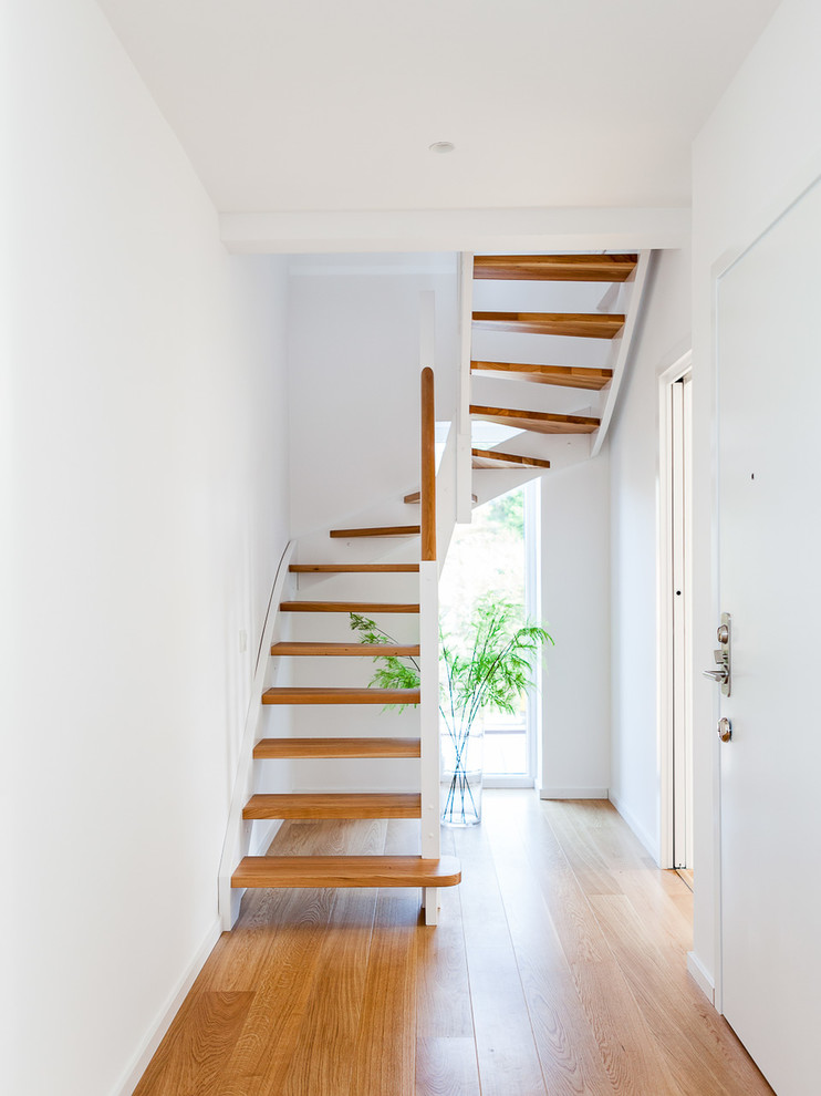Aménagement d'un escalier sans contremarche scandinave en U avec des marches en bois.