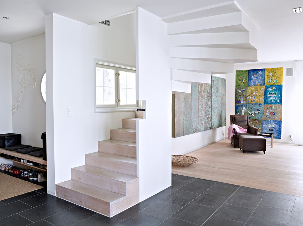 Example of a large trendy wooden curved staircase design in Stockholm with wooden risers