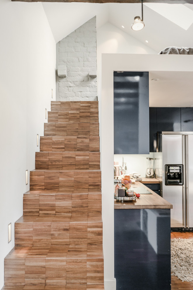 Cette image montre un escalier droit design de taille moyenne avec des marches en bois, des contremarches en bois et éclairage.