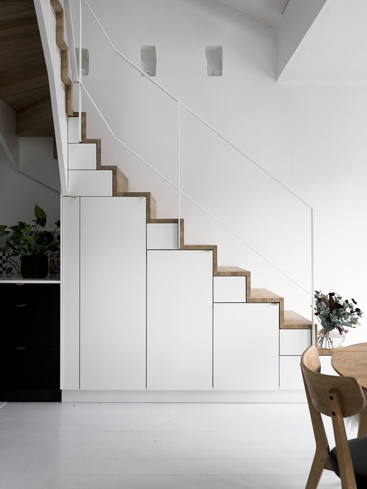 Пример оригинального дизайна: угловая деревянная лестница среднего размера в скандинавском стиле с деревянными ступенями и кладовкой или шкафом под ней