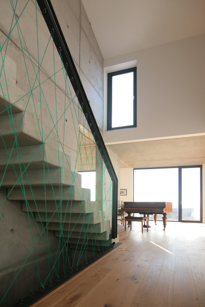 Свежая идея для дизайна: большая прямая бетонная лестница в современном стиле с бетонными ступенями - отличное фото интерьера