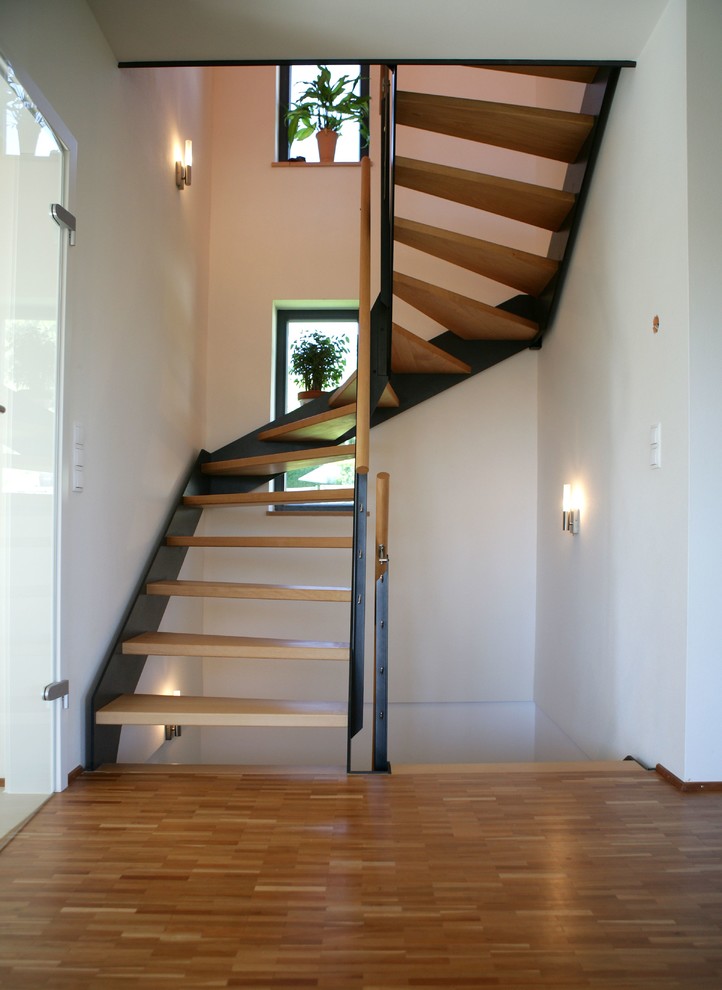 На фото: изогнутая лестница среднего размера в современном стиле с деревянными ступенями без подступенок с