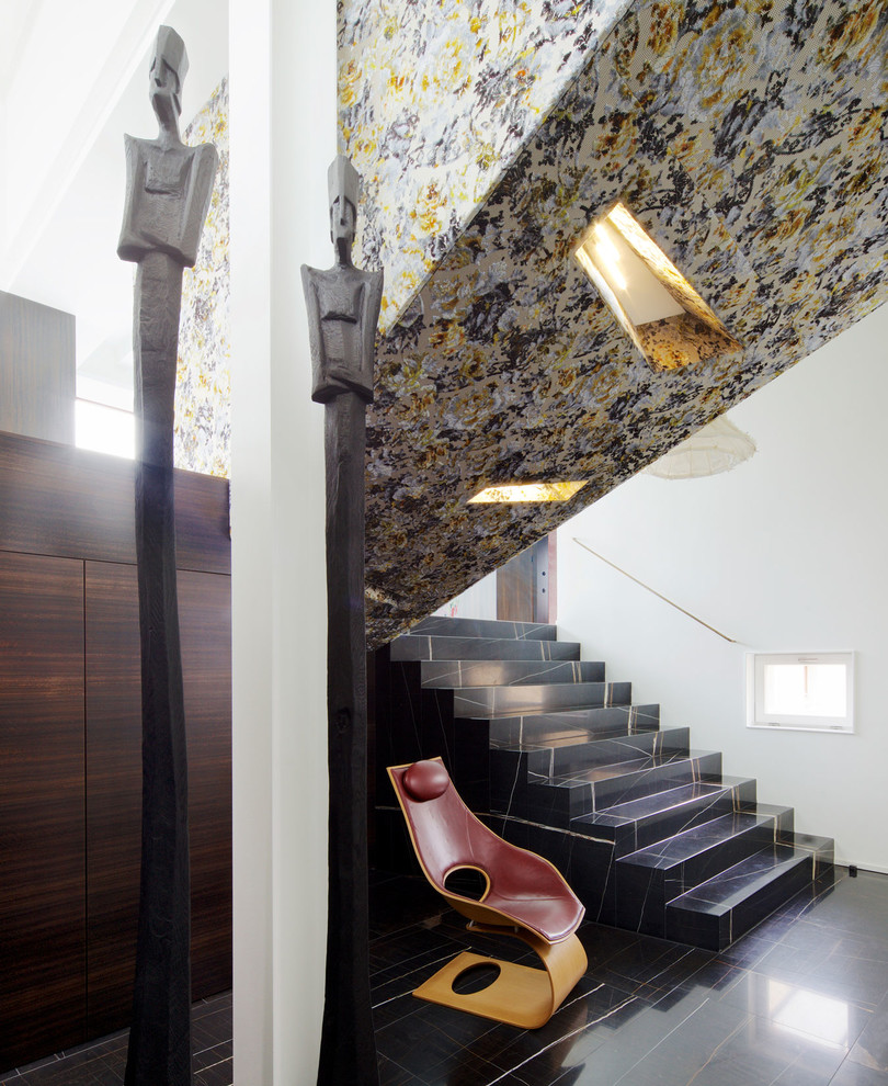 Example of a large asian marble u-shaped staircase design in Leipzig with marble risers