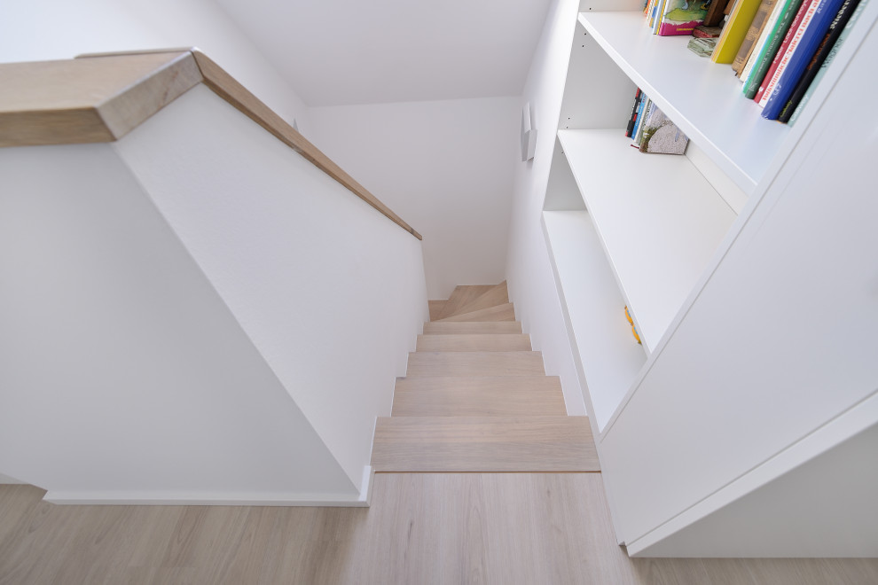 Стильный дизайн: изогнутая деревянная лестница среднего размера в стиле модернизм с деревянными ступенями и стеклянными перилами - последний тренд