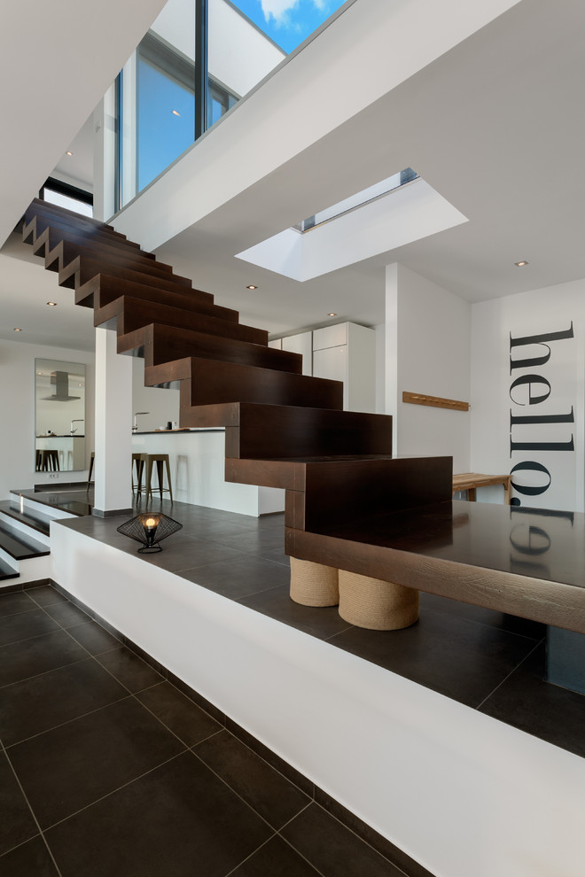 Modelo de escalera recta actual extra grande con escalones de madera, contrahuellas de madera y barandilla de vidrio