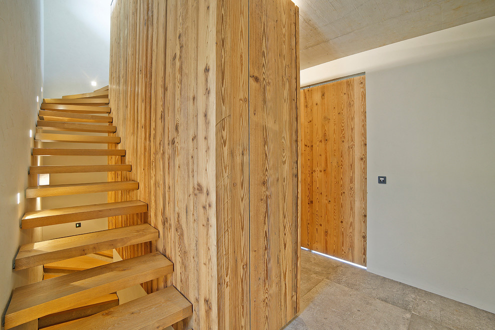 Mittelgroße, Gewendelte Moderne Treppe mit gebeizten Holz-Treppenstufen und offenen Setzstufen in München