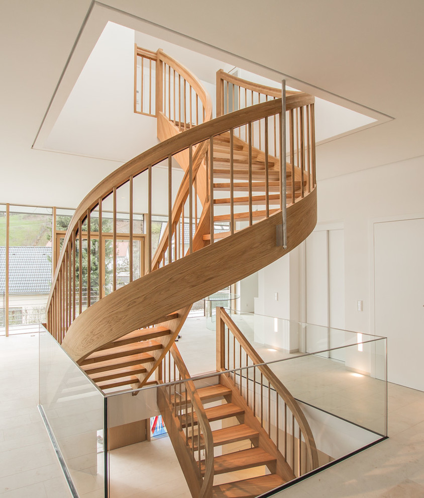 Imagen de escalera curva contemporánea con escalones de madera