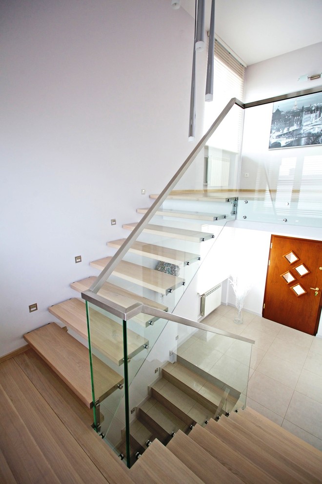 Пример оригинального дизайна: большая прямая лестница в современном стиле с деревянными ступенями без подступенок