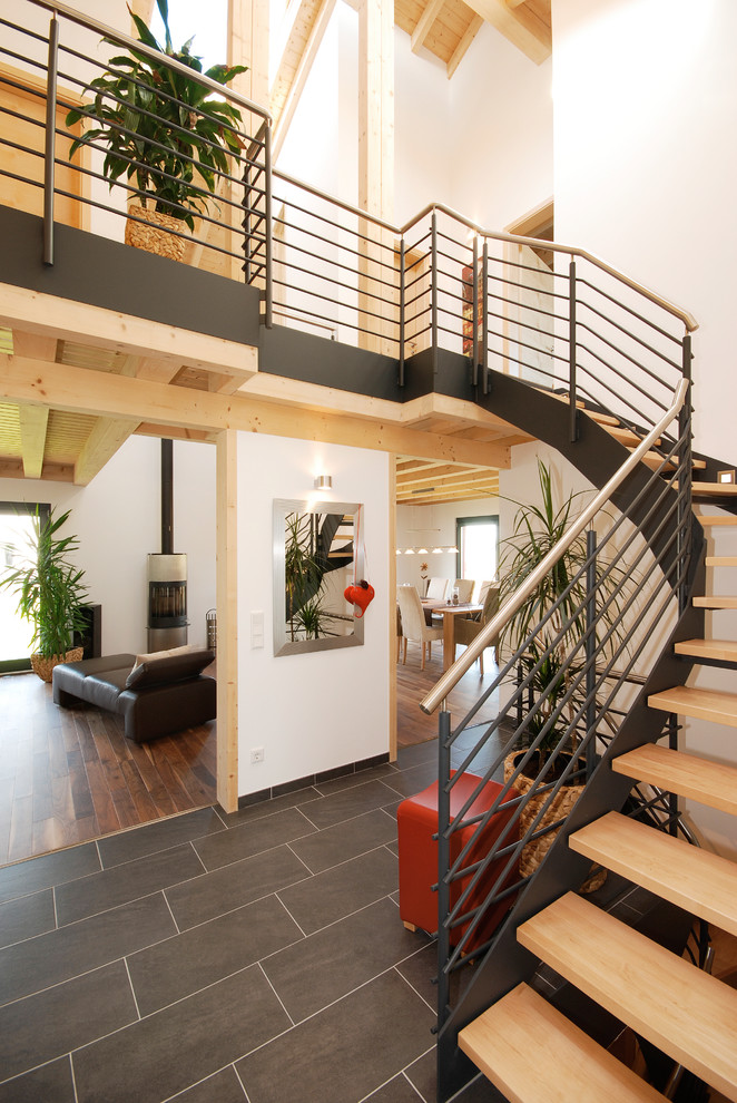 Пример оригинального дизайна: изогнутая лестница в современном стиле с деревянными ступенями без подступенок