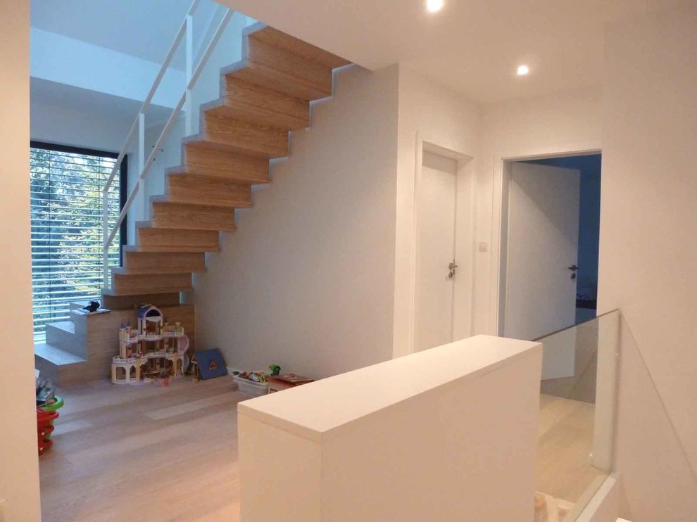 Foto de escalera contemporánea con escalones de madera pintada, contrahuellas de madera pintada y barandilla de metal