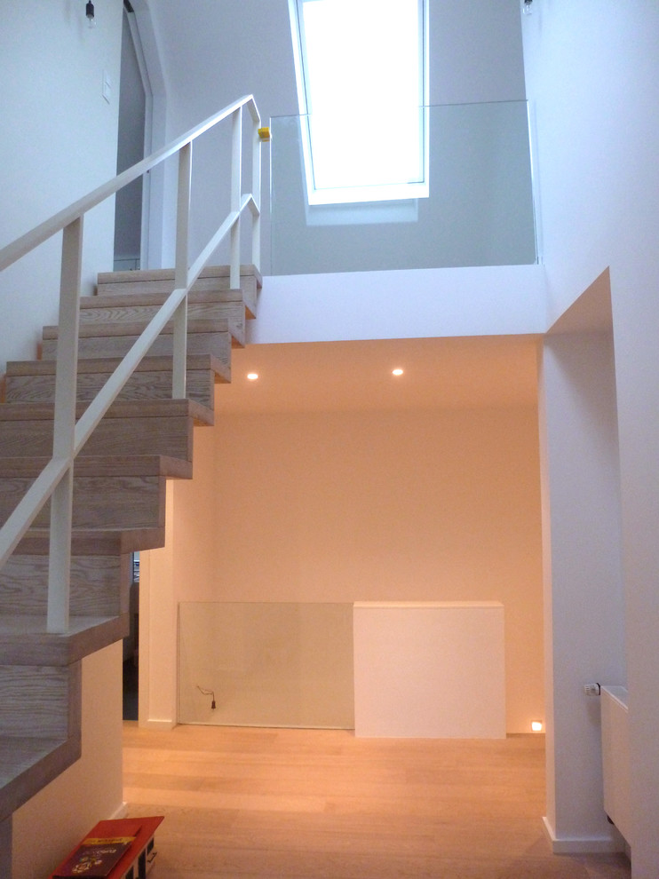 Moderne Treppe mit gebeizten Holz-Treppenstufen, gebeizten Holz-Setzstufen und Stahlgeländer in Düsseldorf
