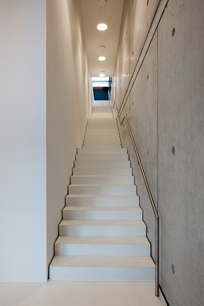 フランクフルトにある広いモダンスタイルのおしゃれな直階段 (コンクリートの蹴込み板、金属の手すり) の写真