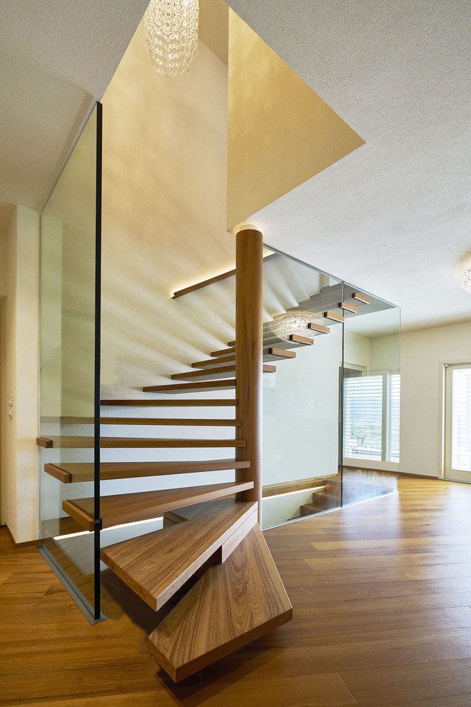 Gewendeltes, Mittelgroßes Modernes Treppengeländer Glas mit gebeizten Holz-Treppenstufen und offenen Setzstufen in München