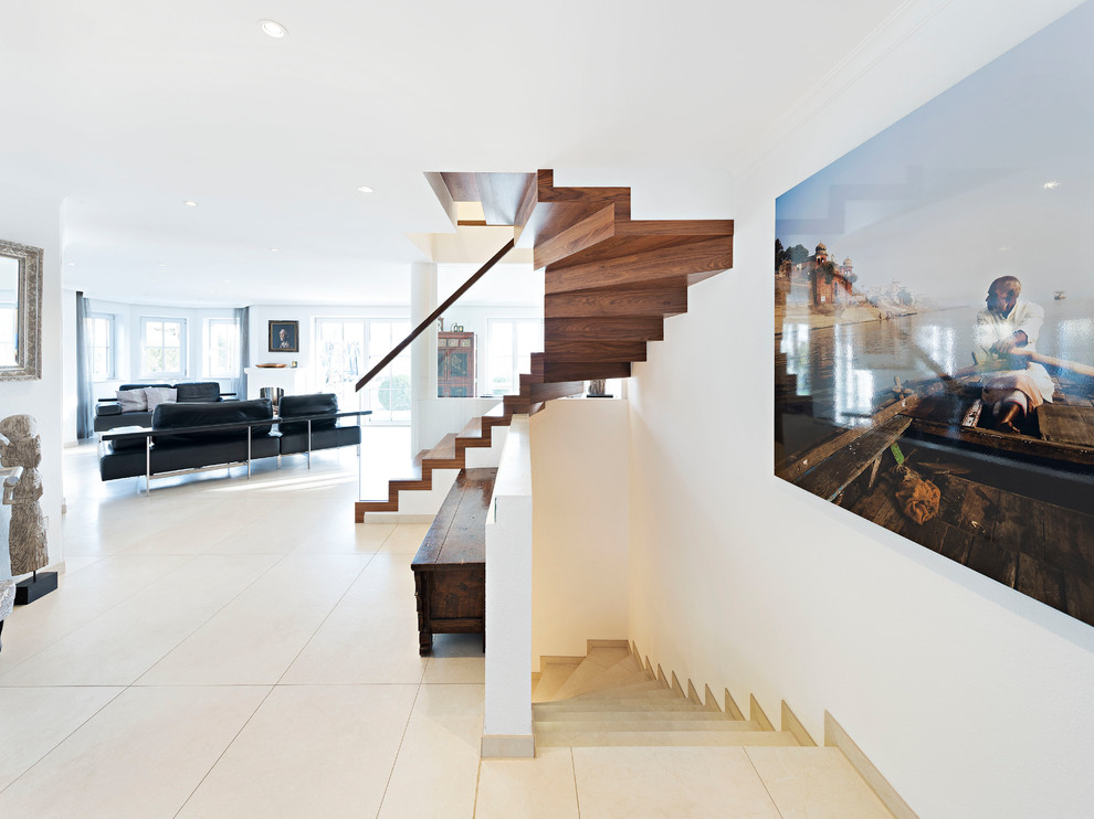 Inspiration pour un grand escalier peint courbe design avec des marches en bois peint, un garde-corps en matériaux mixtes et éclairage.