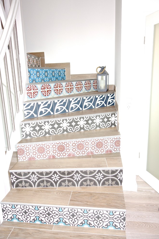 Imagen de escalera curva de estilo de casa de campo de tamaño medio con escalones con baldosas, contrahuellas con baldosas y/o azulejos y barandilla de madera