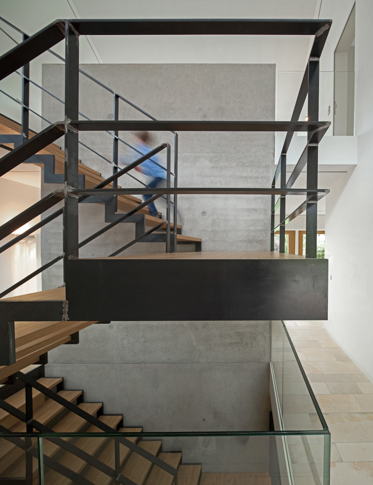 Mittelgroße Moderne Holztreppe in U-Form mit offenen Setzstufen und Stahlgeländer in München
