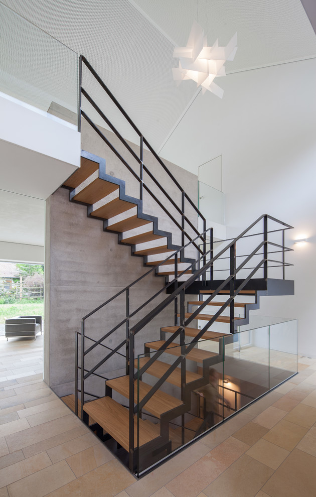 Imagen de escalera en U actual de tamaño medio sin contrahuella con escalones de madera y barandilla de metal