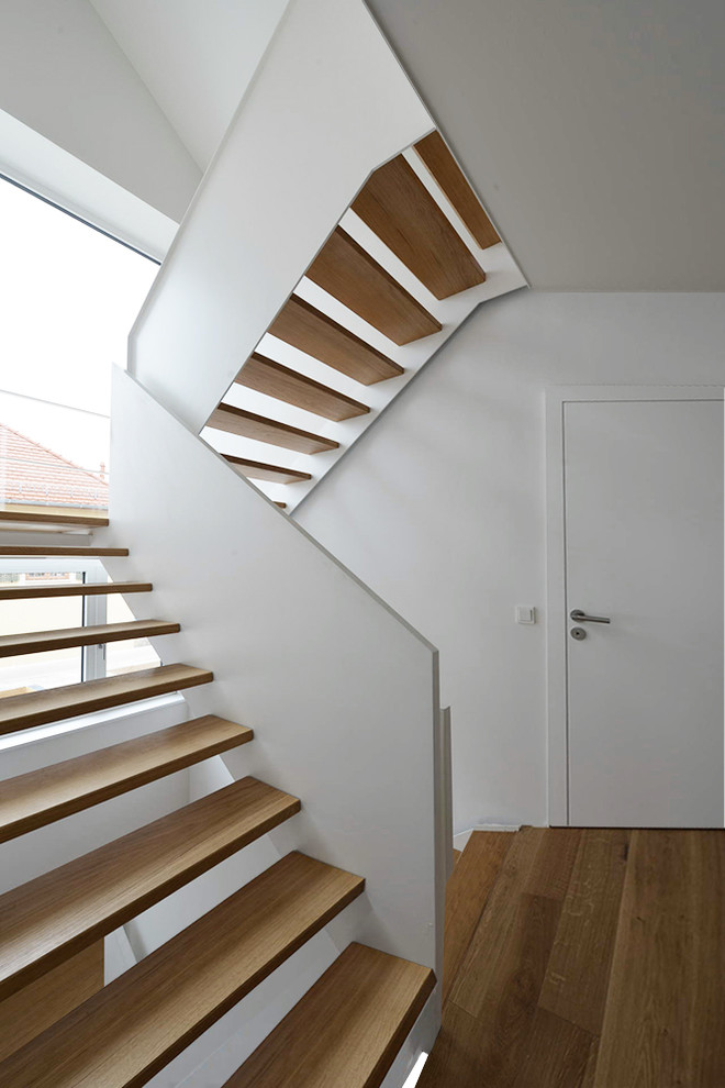 Foto de escalera en U actual de tamaño medio sin contrahuella con escalones de madera