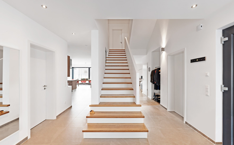 На фото: прямая лестница среднего размера в скандинавском стиле с деревянными ступенями с