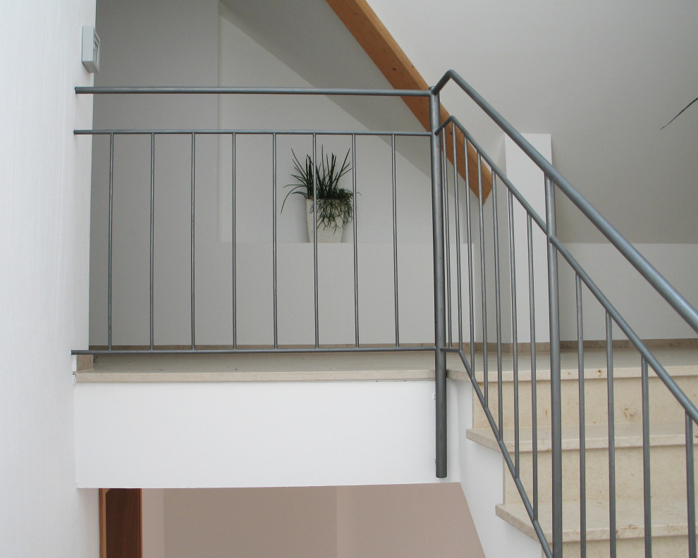 Exemple d'un grand escalier droit tendance en marbre avec des contremarches en marbre et un garde-corps en métal.