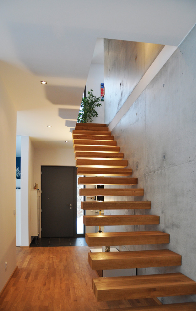 Medium sized contemporary wood floating staircase in Dresden with open risers.