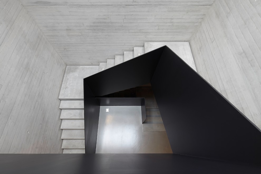 На фото: п-образная бетонная лестница среднего размера в современном стиле с бетонными ступенями с