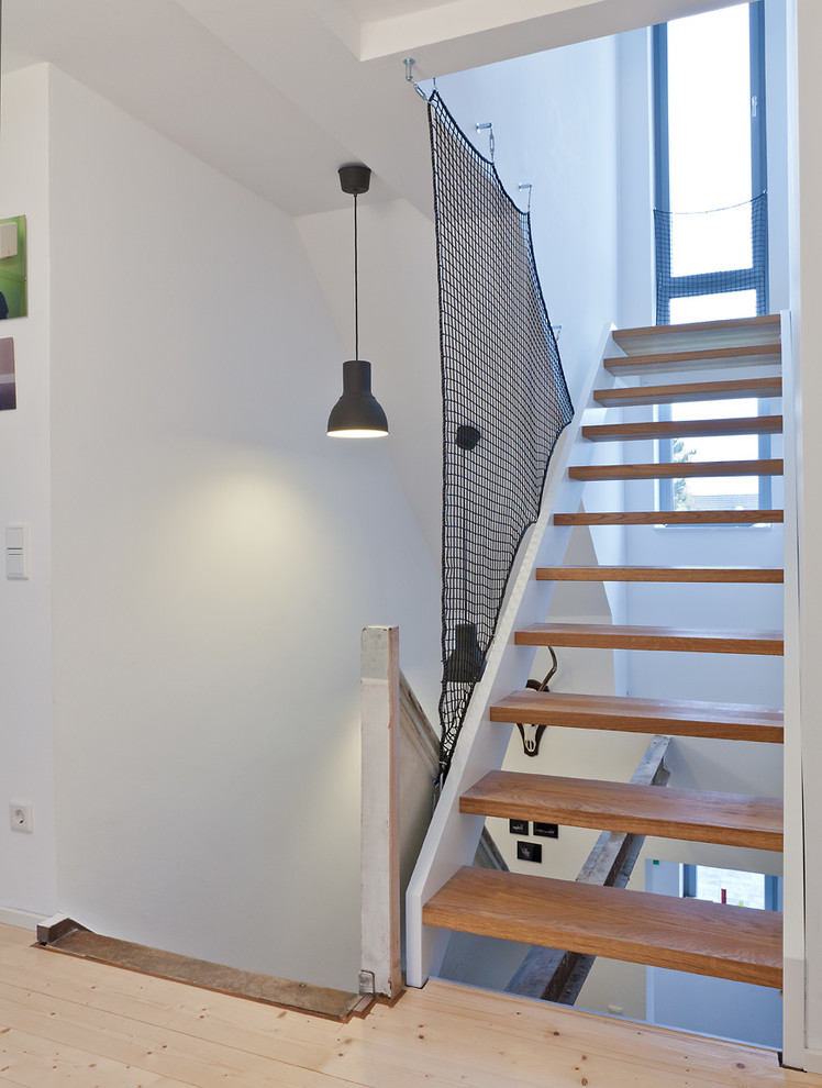 Small contemporary wood l-shaped staircase in Cologne with open risers.