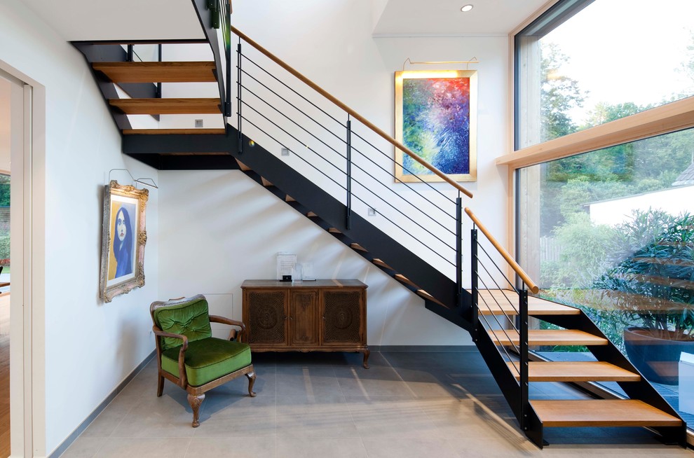 Свежая идея для дизайна: п-образная лестница среднего размера в современном стиле с перилами из смешанных материалов и деревянными ступенями без подступенок - отличное фото интерьера