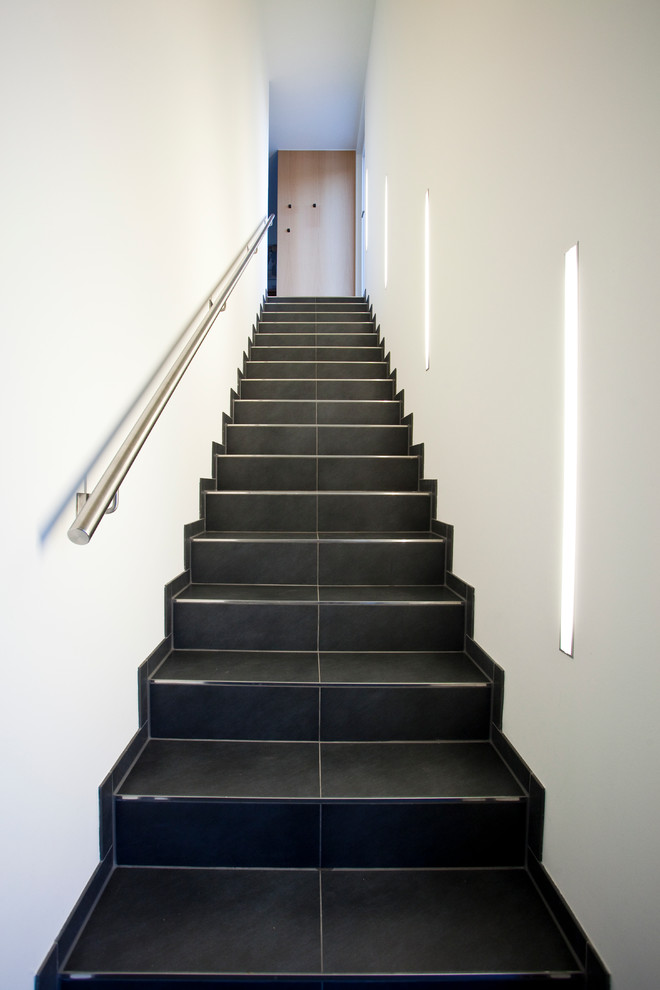 На фото: большая прямая лестница в современном стиле с ступенями из плитки и подступенками из плитки