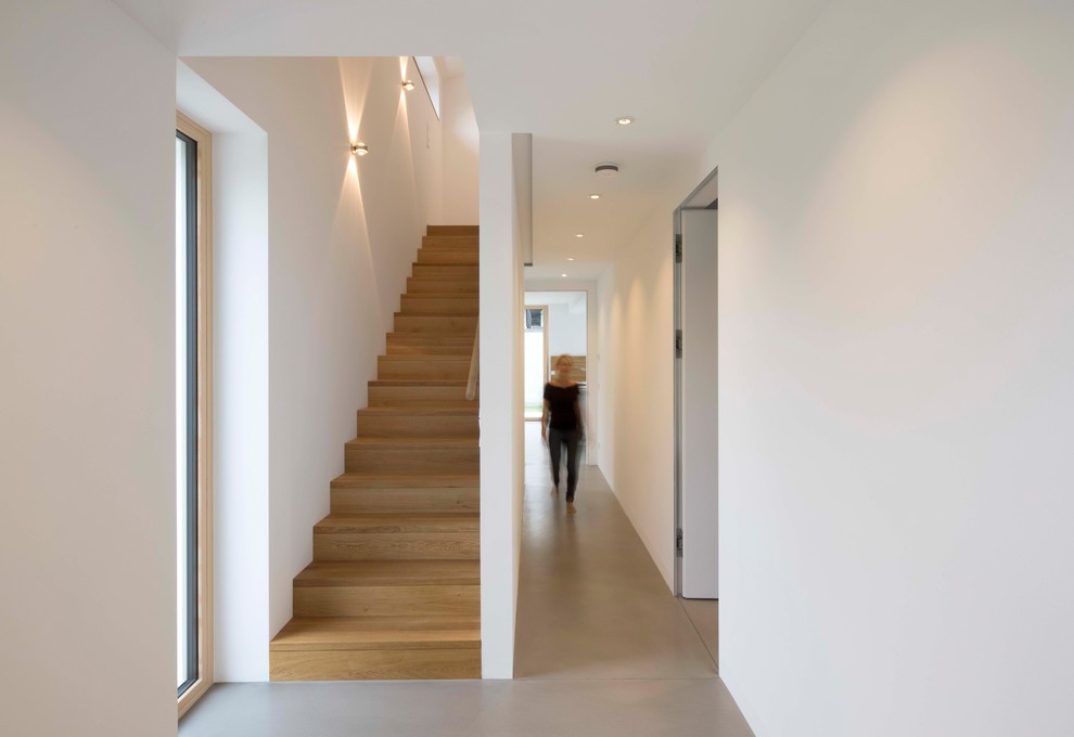 Modelo de escalera recta minimalista de tamaño medio con escalones de madera pintada, contrahuellas de madera pintada y barandilla de madera